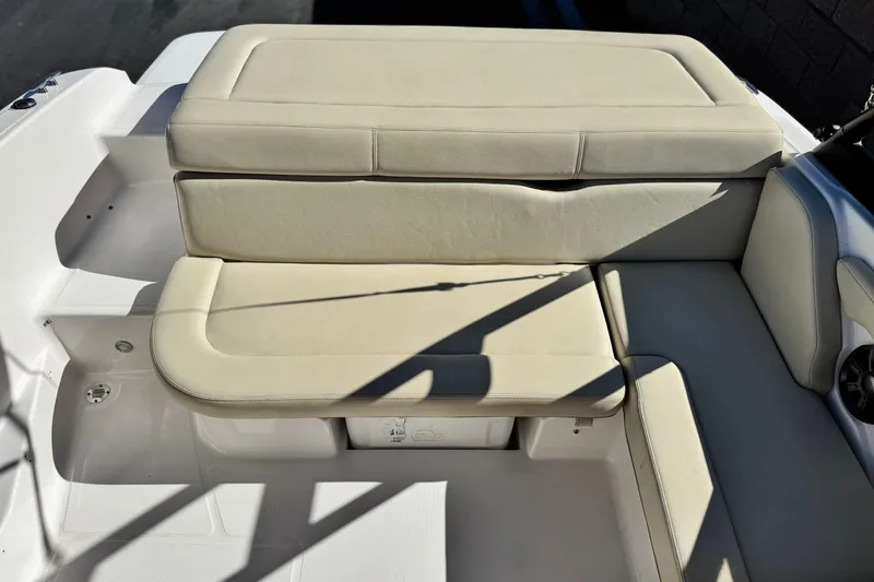 Slide: The Image of 2020 Regal 1900 ES Bowrider boat interior with beige seating and storage compartment. - 15