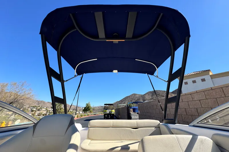Slide: The Image of 2020 Regal 1900 ES Bowrider with blue canopy, scenic mountain backdrop. - 8