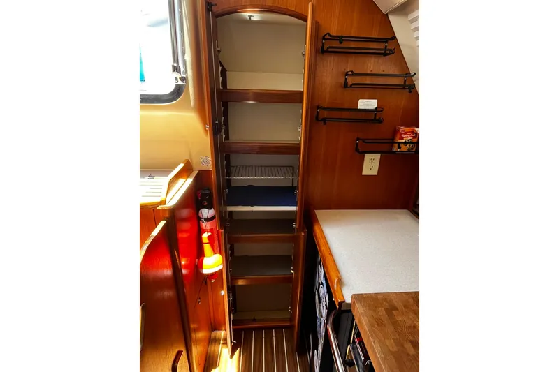 Slide: The Image of 2006 Hunter 41 Deck Salon interior with wooden cabinetry and open shelving. - 12