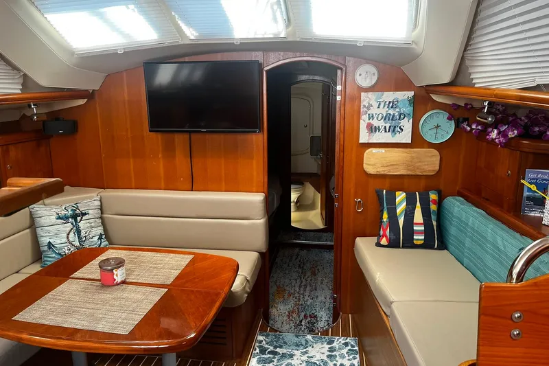 Slide: The Image of Interior of 2006 Hunter 41 Deck Salon with cozy seating, TV, and nautical decor. - 13