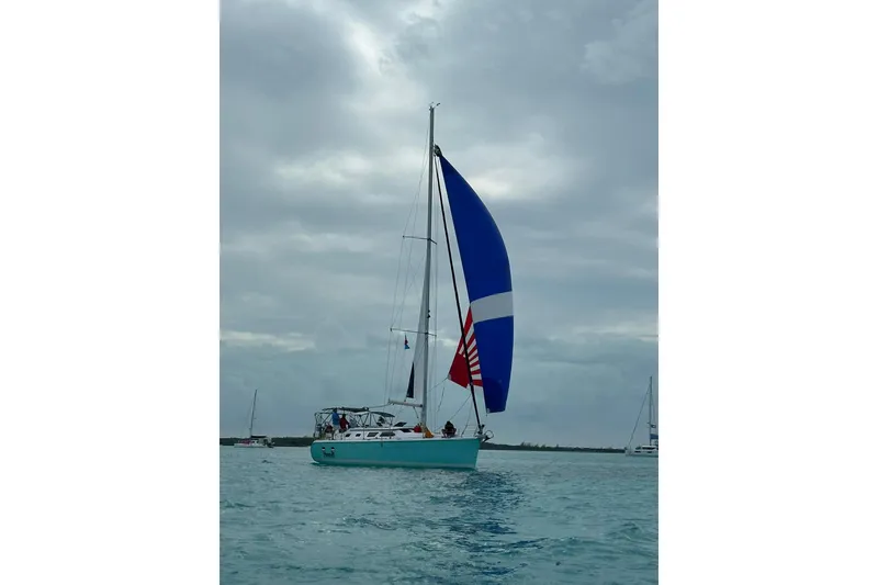 Slide: The Image of Sailing yacht Hunter 41 Deck Salon 2006 with blue and white sails on open water. - 2