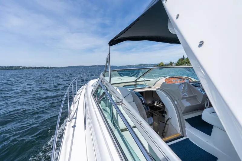 Slide: The Image of 1998 Avanti 4085 Sunbridge yacht cruising on a serene lake under a clear blue sky. - 35