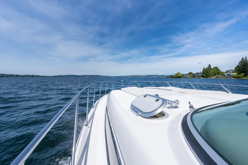 Slide: The Image of 1998 Avanti 4085 Sunbridge yacht cruising on a serene lake under a clear blue sky. - 36