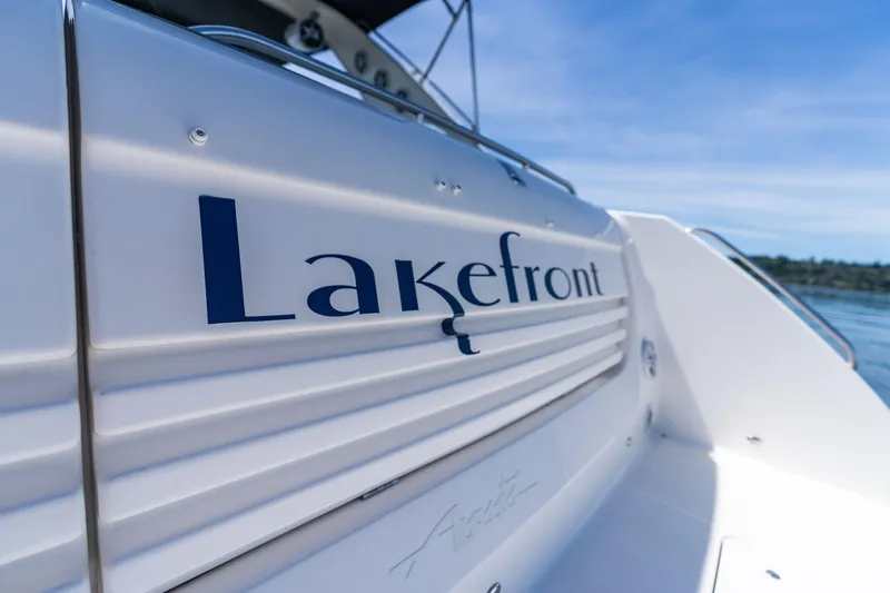 Slide: The Image of 1998 Avanti 4085 Sunbridge boat with "Lakefront" text, docked on a sunny day. - 4