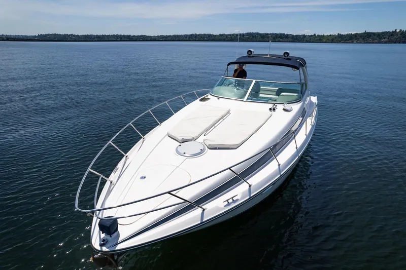 Slide: The Image of 1998 Avanti 4085 Sunbridge yacht on calm water, showcasing sleek design and spacious deck. - 44