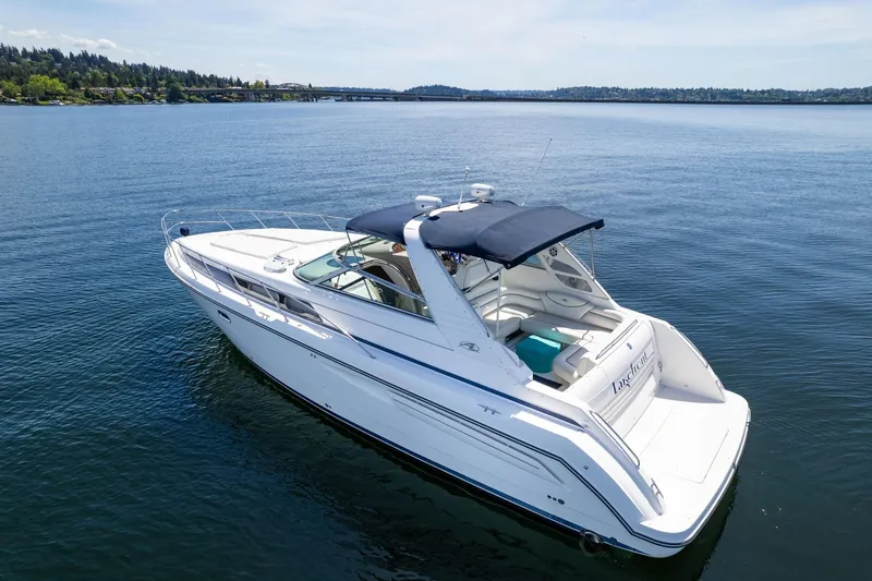 Slide: The Image of 1998 Avanti 4085 Sunbridge yacht cruising on a serene lake under a clear sky. - 46