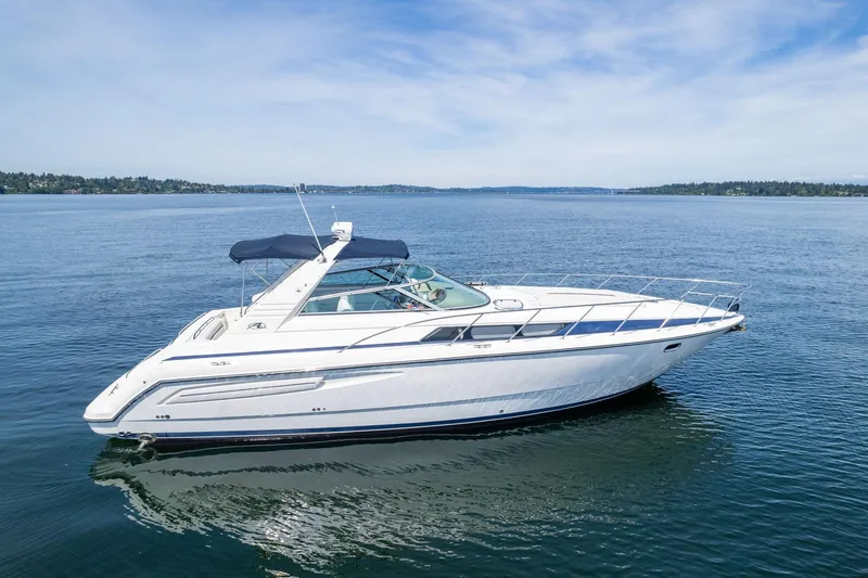 Slide: The Image of 1998 Avanti 4085 Sunbridge yacht cruising on a serene blue lake under a clear sky. - 48