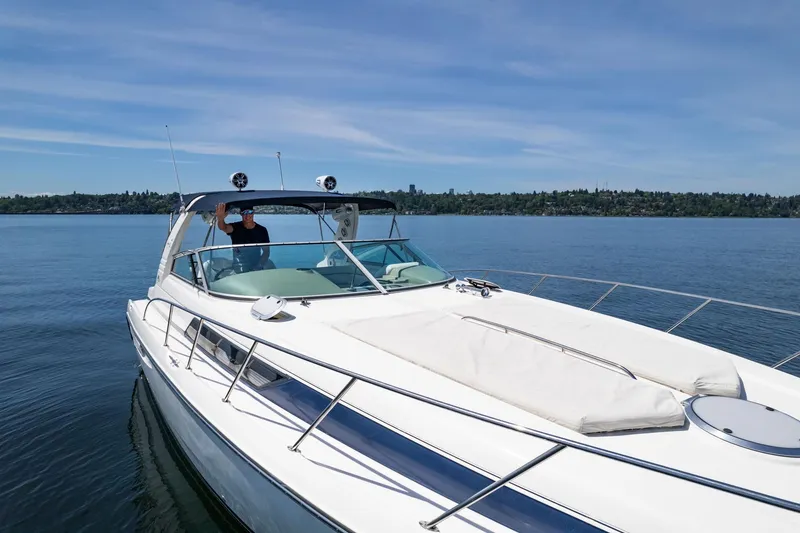 Slide: The Image of 1998 Avanti 4085 Sunbridge yacht cruising on a serene lake under a clear blue sky. - 49
