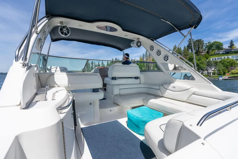Slide: The Image of 1998 Avanti 4085 Sunbridge yacht interior with white seating and blue canopy on a sunny day. - 5