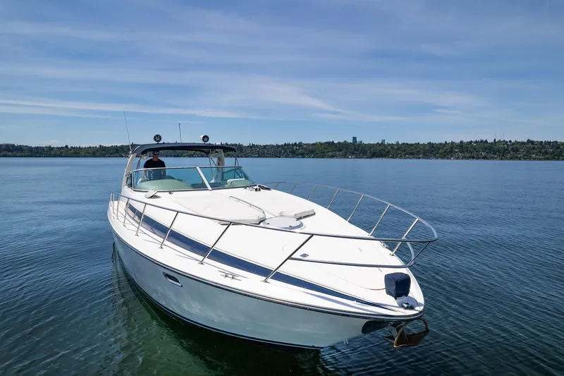 Slide: The Image of 1998 Avanti 4085 Sunbridge yacht cruising on a calm lake under a clear blue sky. - 50