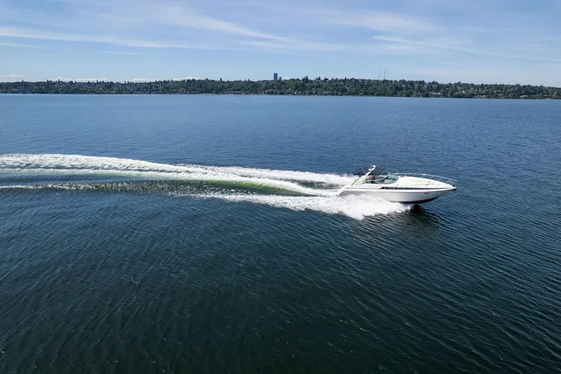 Slide: The Image of 1998 Avanti 4085 Sunbridge cruising on a serene lake under a clear blue sky. - 52