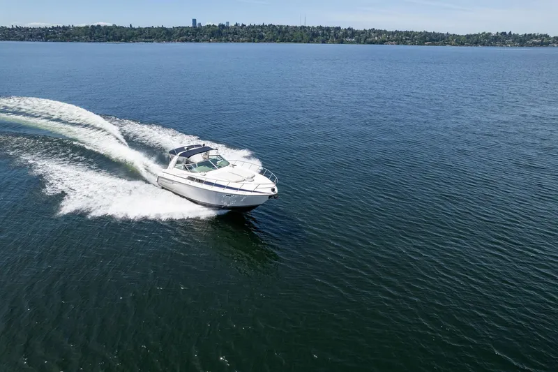 Slide: The Image of 1998 Avanti 4085 Sunbridge cruising on open water, creating a dynamic wake. - 53