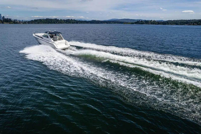 Slide: The Image of 1998 Avanti 4085 Sunbridge cruising on a scenic lake with forested shoreline. - 54