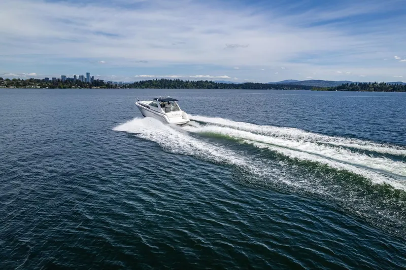 Slide: The Image of 1998 Avanti 4085 Sunbridge cruising on a scenic lake with city skyline. - 55
