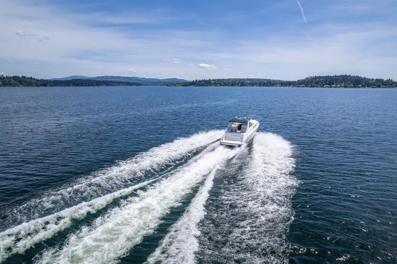 Slide: The Image of 1998 Avanti 4085 Sunbridge cruising on a serene lake under a clear blue sky. - 56