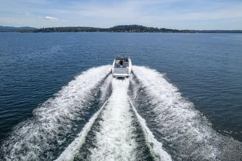 Slide: The Image of 1998 Avanti 4085 Sunbridge cruising on a serene lake, leaving a wake trail. - 57