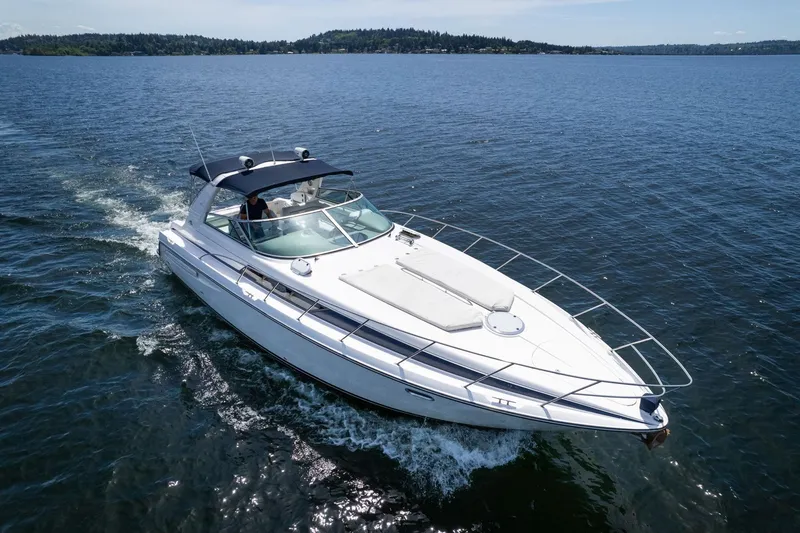 Slide: The Image of 1998 Avanti 4085 Sunbridge cruising on a serene lake under clear skies. - 58