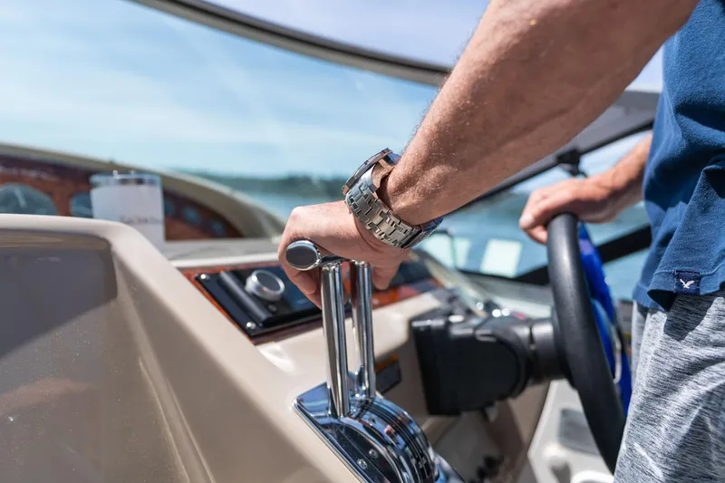 Slide: The Image of Person steering 1998 Avanti 4085 Sunbridge boat, close-up of controls and wristwatch. - 61