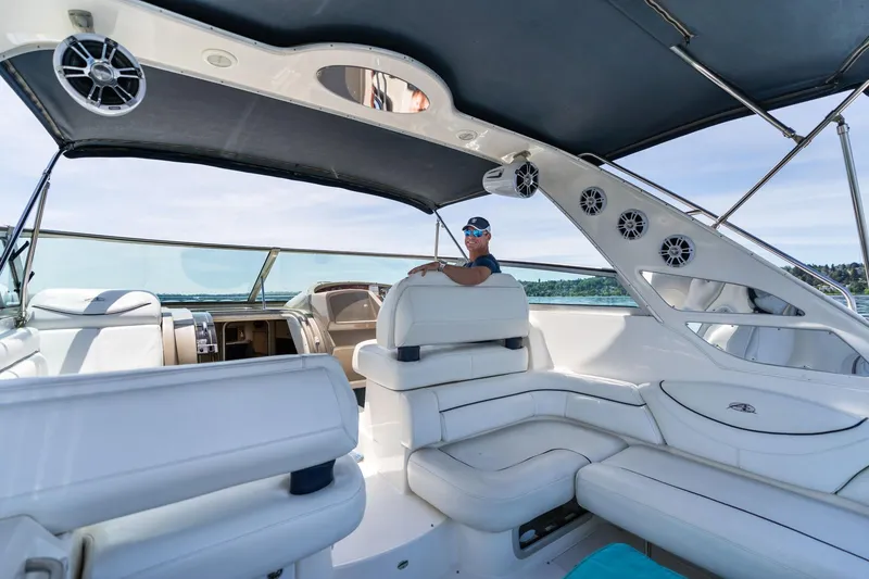 Slide: The Image of 1998 Avanti 4085 Sunbridge yacht interior with person at helm, featuring white seating. - 62