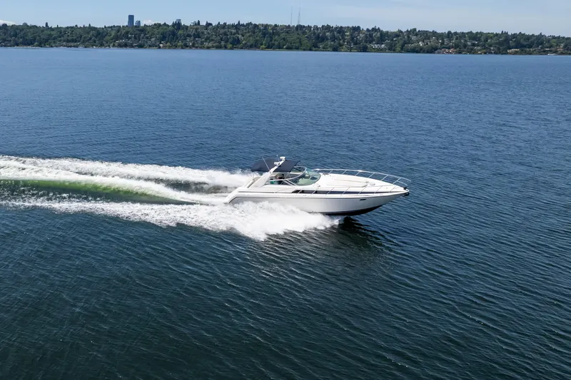 Slide: The Image of 1998 Avanti 4085 Sunbridge cruising on a serene lake with distant shoreline. - 68