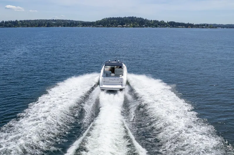 Slide: The Image of 1998 Avanti 4085 Sunbridge cruising on a serene lake with scenic background. - 70