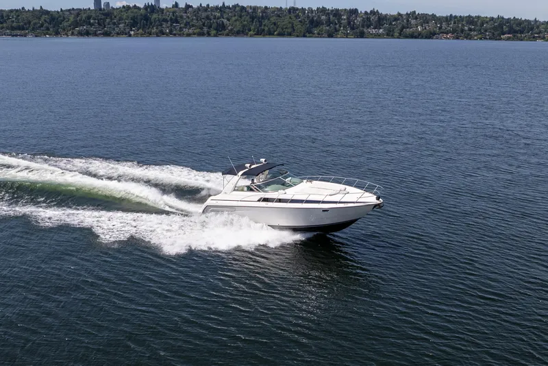 Slide: The Image of 1998 Avanti 4085 Sunbridge cruising on a serene lake with distant shoreline. - 71