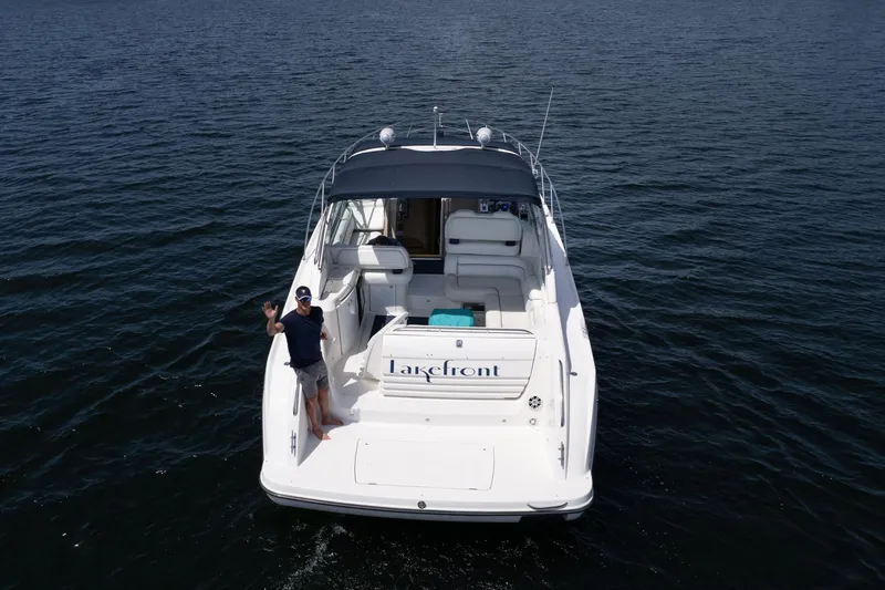 Slide: The Image of 1998 Avanti 4085 Sunbridge boat on water, person waving on deck. - 74