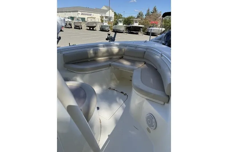 Slide: The Image of 2015 Cobia 237CC boat interior with cushioned seating in a parking lot. - 6