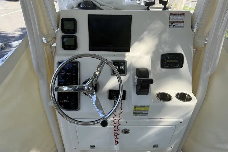 Slide: The Image of 2015 Cobia 237CC boat console with steering wheel, controls, and display screens. - 8