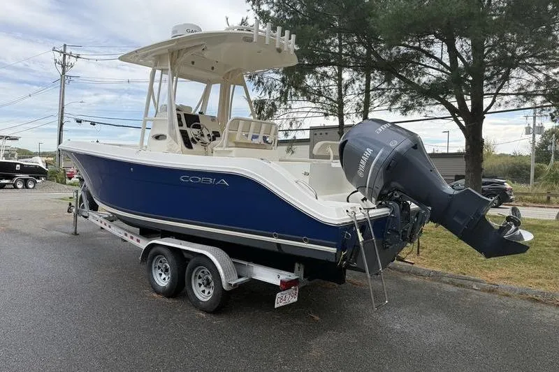 Slide: The Image of 2015 Cobia 237CC boat on trailer with Yamaha outboard motor, parked outdoors. - 9