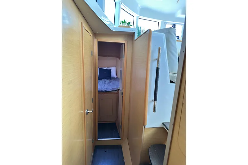 Slide: The Image of Interior cabin of 2015 Lagoon 380 S2 catamaran, featuring cozy bed and wooden finish. - 20