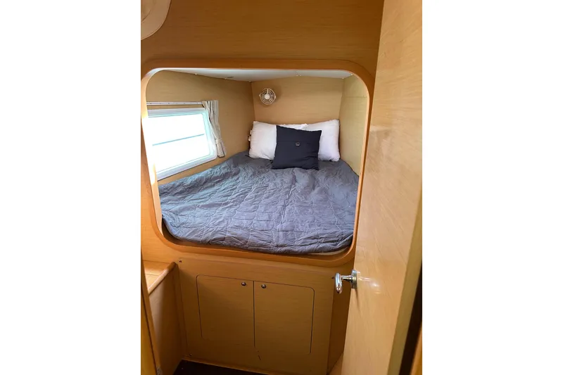 Slide: The Image of Cozy cabin interior of 2015 Lagoon 380 S2 catamaran with bed and window. - 21