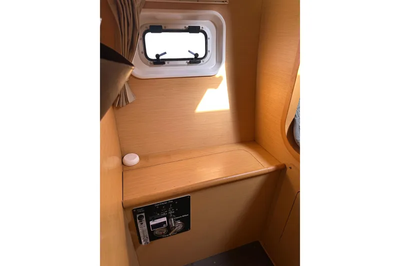 Slide: The Image of Interior of 2015 Lagoon 380 S2 yacht with wooden paneling and small window. - 22