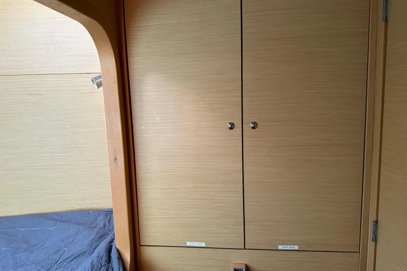 Slide: The Image of Interior of 2015 Lagoon 380 S2 yacht with wooden cabinets and bed. - 24
