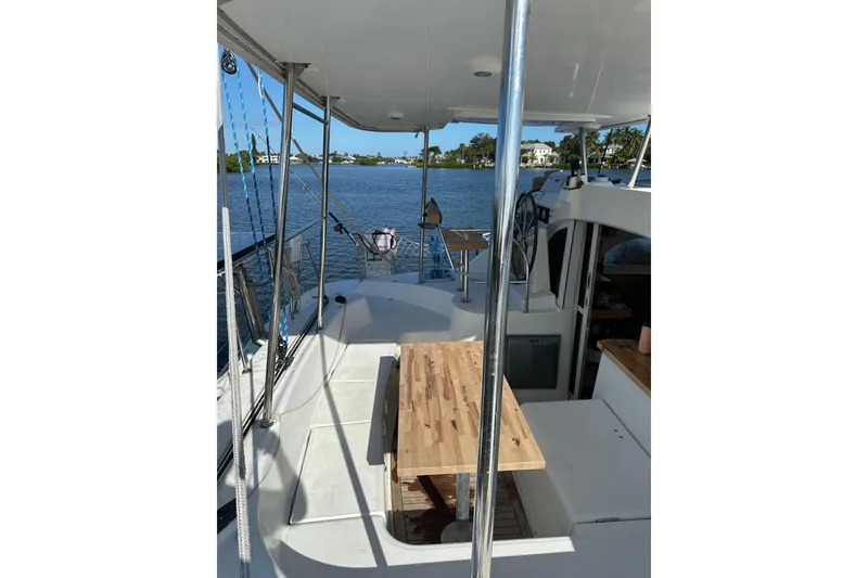Slide: The Image of 2015 Lagoon 380 S2 catamaran deck with wooden table, overlooking serene water. - 27