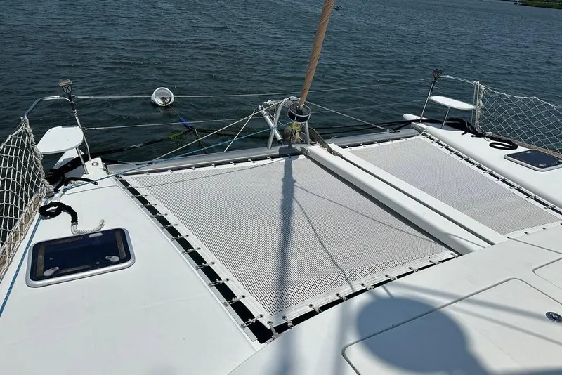 Slide: The Image of 2015 Lagoon 380 S2 catamaran deck with netting over water. - 29