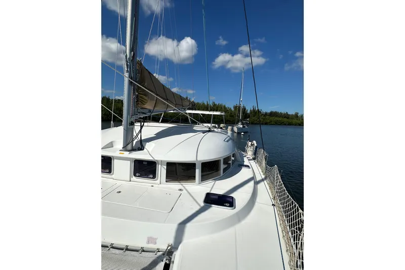 Slide: The Image of 2015 Lagoon 380 S2 catamaran on calm water under blue sky. - 33