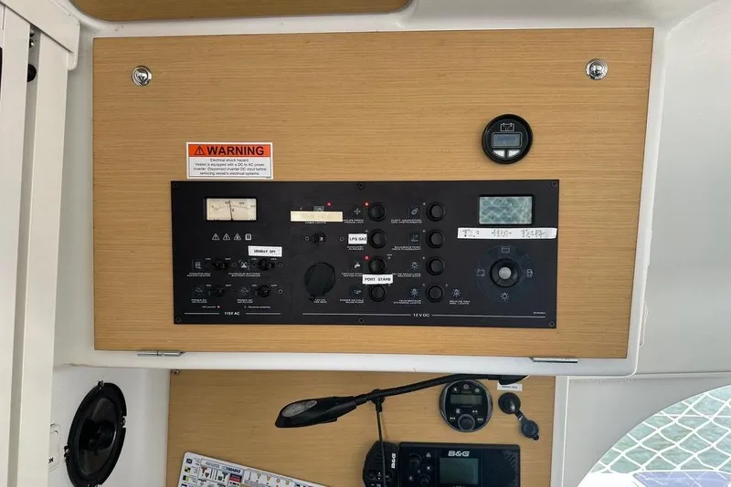 Slide: The Image of Control panel of a 2015 Lagoon 380 S2 catamaran with warning label and instruments. - 38