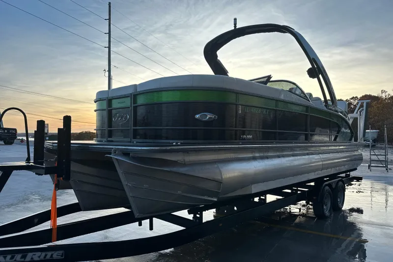 Slide: The Image of 2017 Manitou Xplode 250 pontoon boat on trailer at sunset. - 11