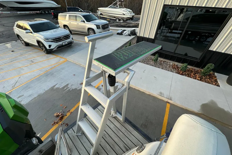 Slide: The Image of Aluminum ladder on a 2017 Manitou Xplode 250 pontoon boat, parked near vehicles and boats. - 30