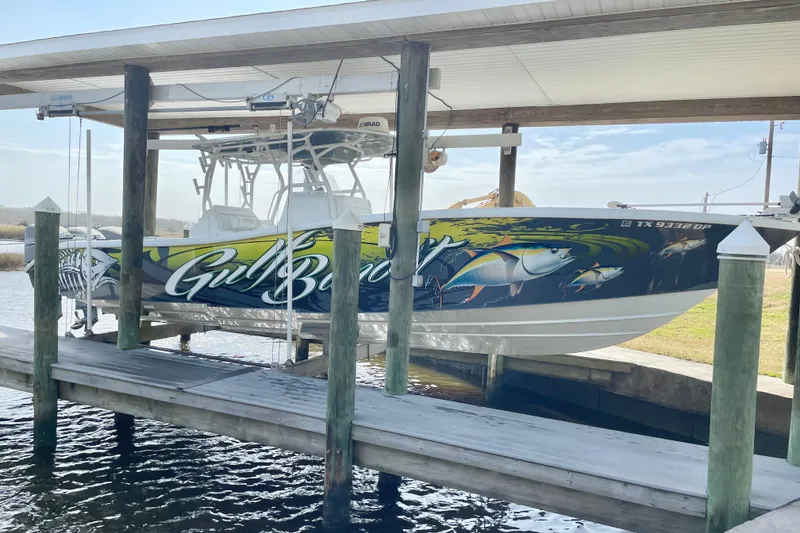 The Image of 2016 Yellowfin 36 Offshore boat on trailer, parked on grass under clear blue sky. - 0