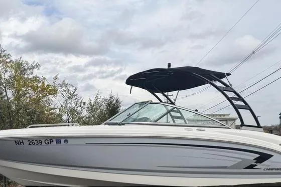The Image of 2023 Chaparral 23 SSi boat with sleek design and black canopy against cloudy sky. - 0