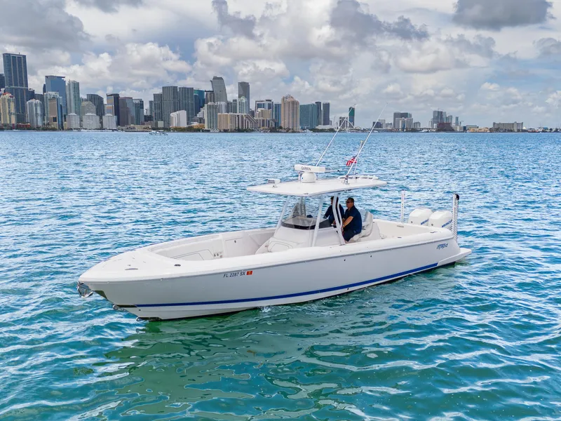 Slide: The Image of 2021 Intrepid 345 Nomad FE boat cruising near city skyline on a sunny day. - 10