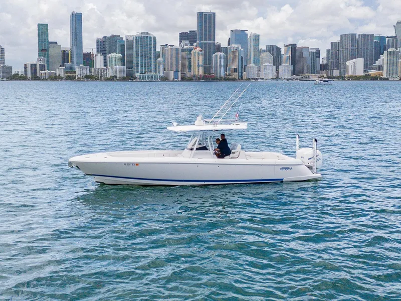 Slide: The Image of 2021 Intrepid 345 Nomad FE boat cruising near city skyline on a sunny day. - 11