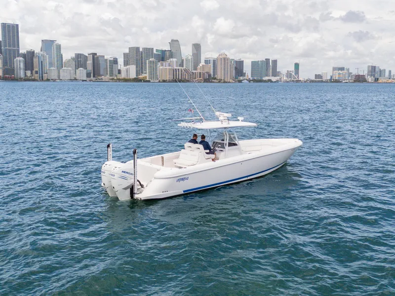 Slide: The Image of 2021 Intrepid 345 Nomad FE boat cruising near city skyline. - 13