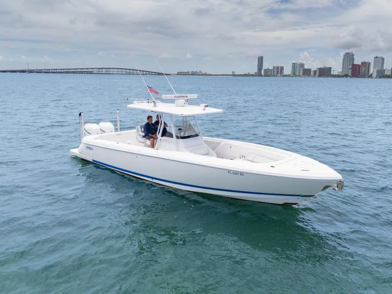 Slide: The Image of 2021 Intrepid 345 Nomad FE boat cruising near city skyline. - 14