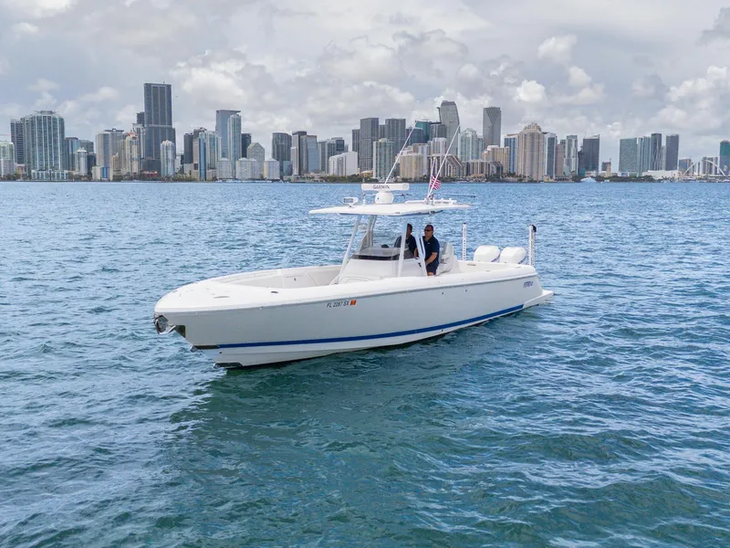 Slide: The Image of 2021 Intrepid 345 Nomad FE boat cruising near city skyline on a clear day. - 16