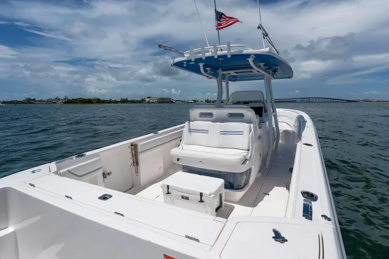 Slide: The Image of 2021 Intrepid 345 Nomad FE boat on water, featuring sleek design and American flag. - 24