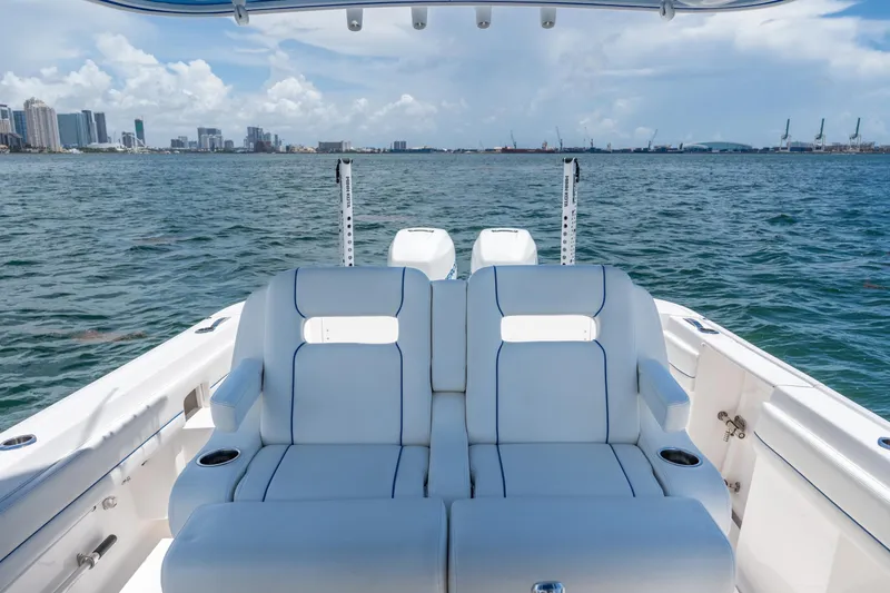 Slide: The Image of 2021 Intrepid 345 Nomad FE boat with luxurious seating, overlooking a city skyline and ocean. - 28