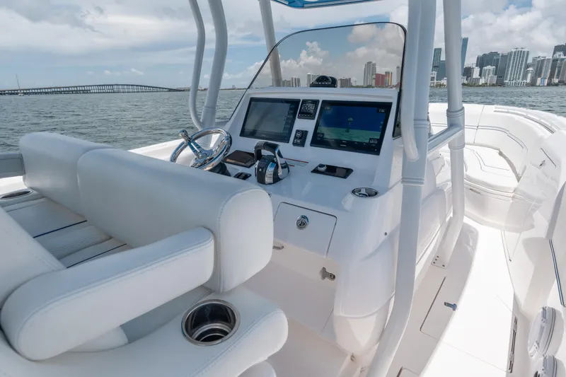 Slide: The Image of 2021 Intrepid 345 Nomad FE boat cockpit with modern navigation system and city skyline view. - 29